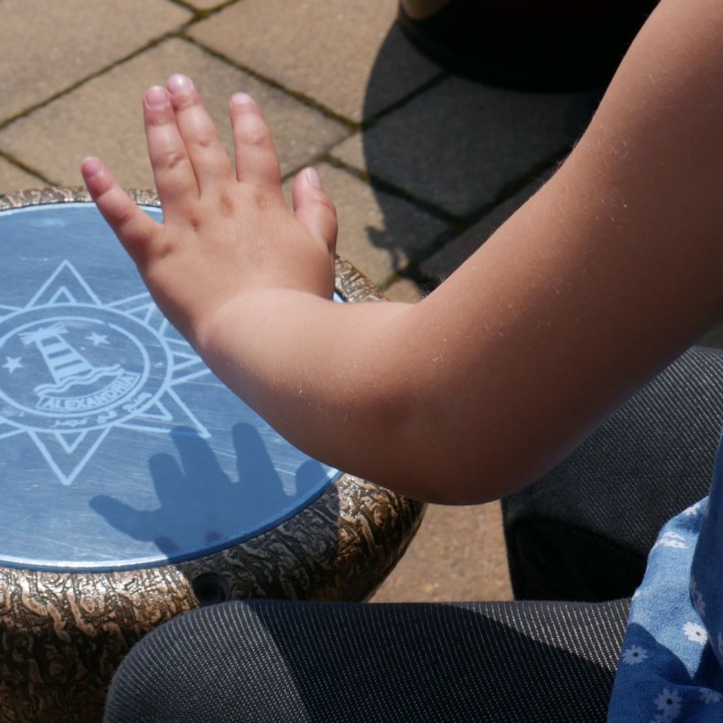 Dziecko trzyma rękę nad niebieskim wzorkiem na ziemi.