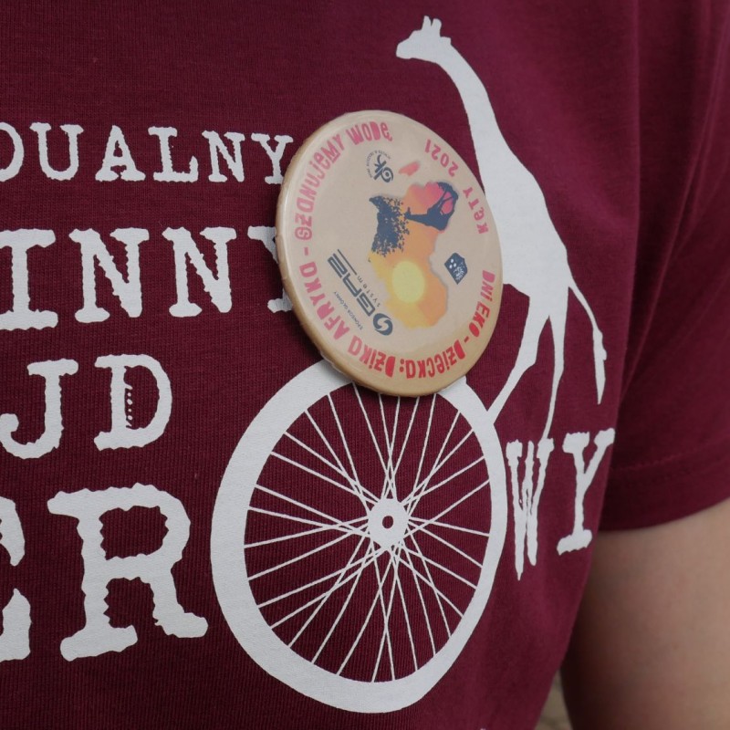 Zbliżenie na koszulkę z rajdu rowerowego oraz przypinkię z napisem dni eko-dziecka.