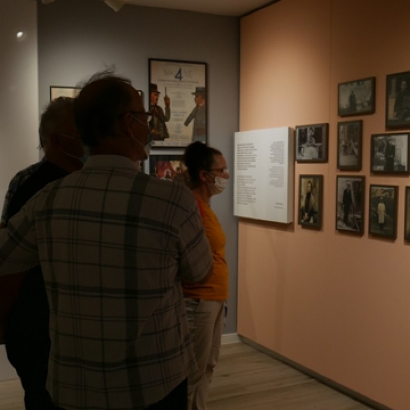 Seniorzy oglądający ścianę z wywieszonymi zdjęciami.