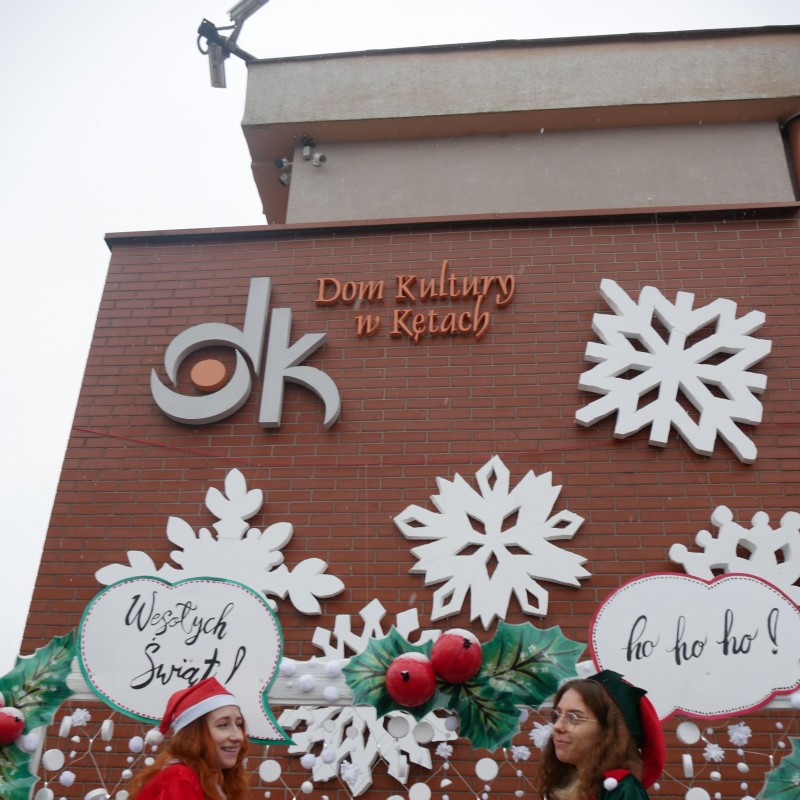 Pani Mikołajka i Pani Elf  na tle ozdób świątecznych na zewnątrz Domu Kultury