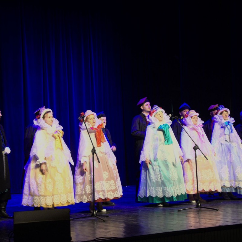 Zespół regionalny „Podłazy” w kostiumach podczas koncertu na scenie domu kultury.