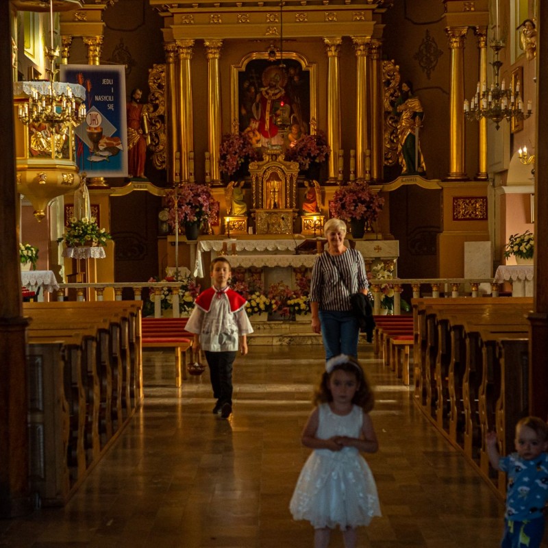 Fot. Łukasz Kuc/Od głównego ołtarza kościoła w stronę wyjścia kierują się kobieta oraz troje małych dzieci.